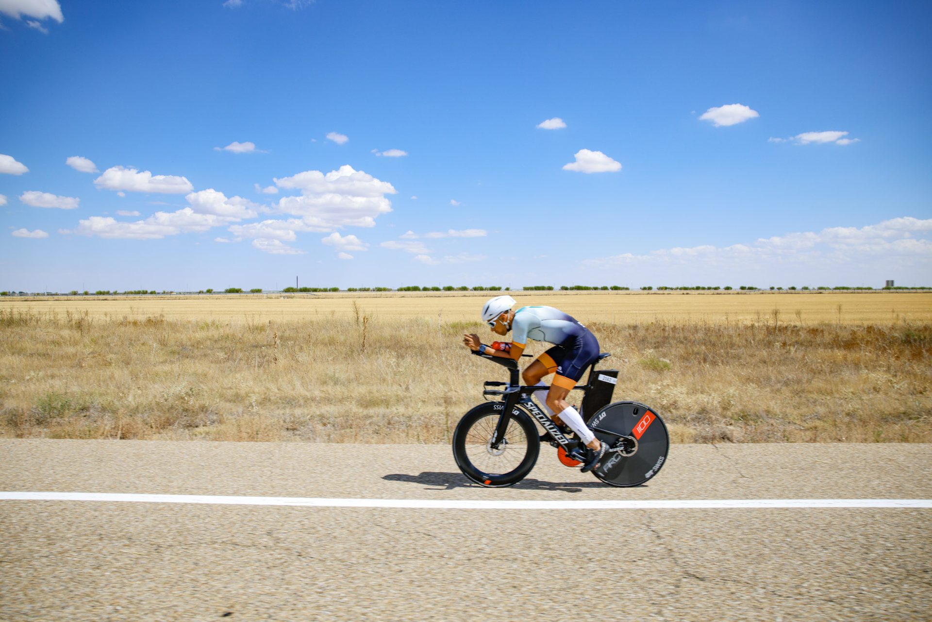 Triatleta rodando entre campos de cereal