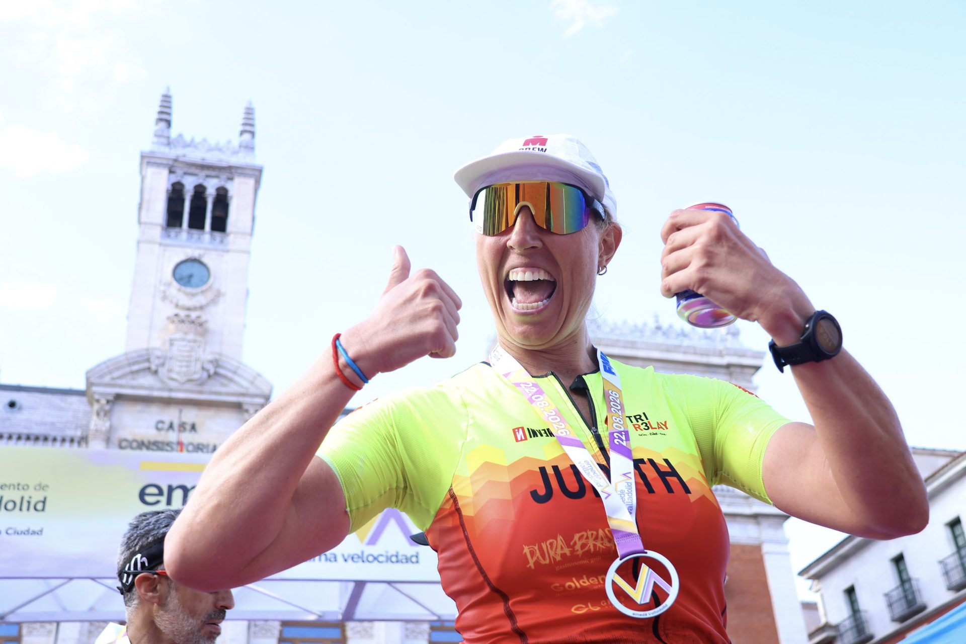 Triatleta celebra con la medalla ante la Casa Consistorial