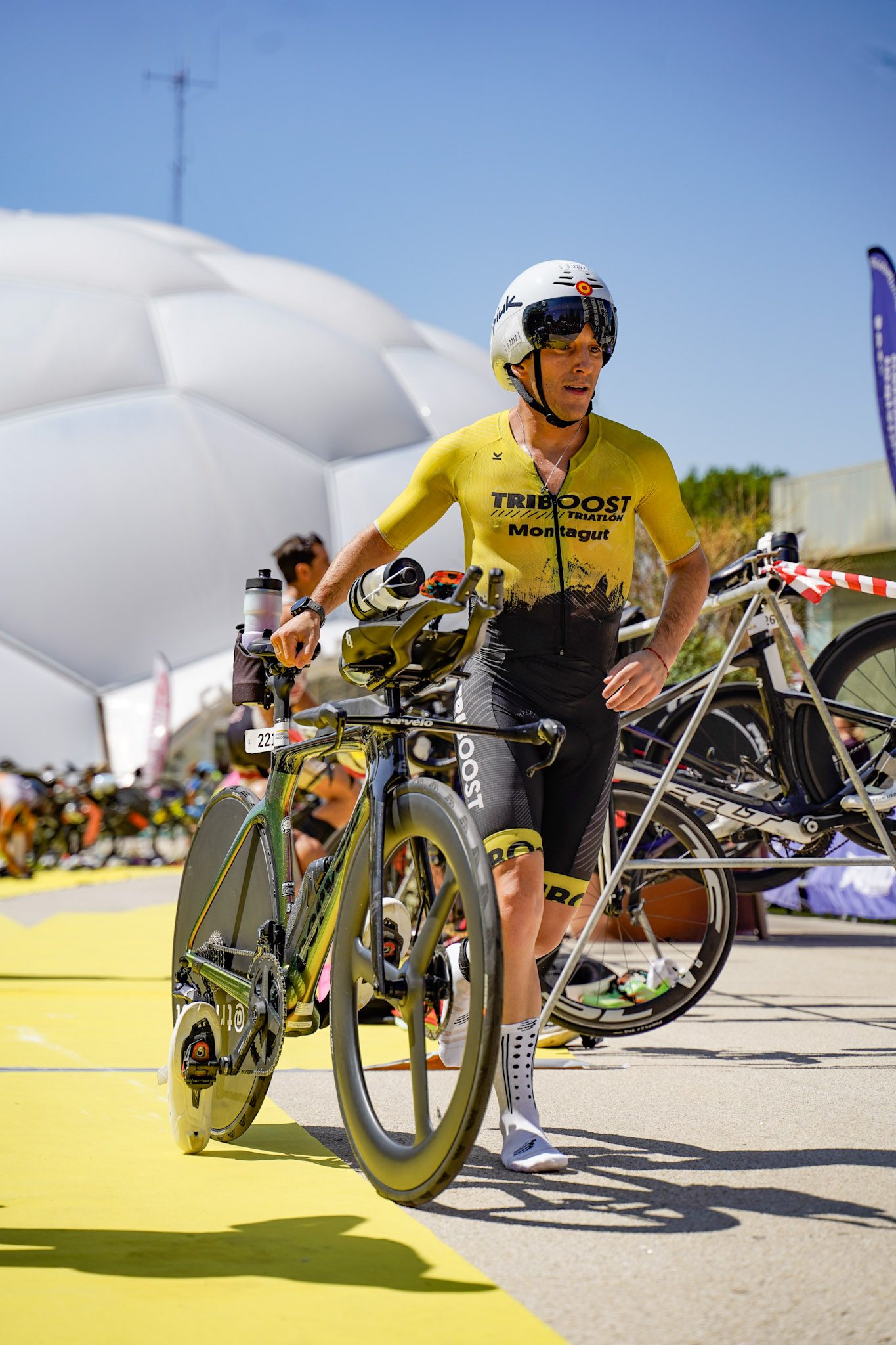 Triatleta saliendo de la transición con la bici, junto a la Cúpula del Milenio